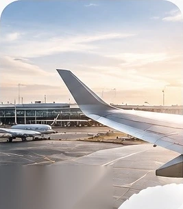 Aircraft wing at an airport stand at sunset